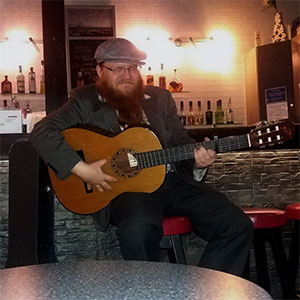 Dolfy playing the guitar at Pikari, pub.